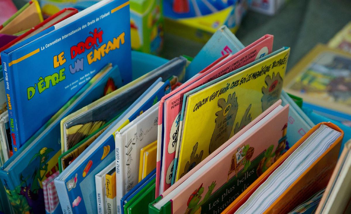 A lot of used books sticking up from their container.