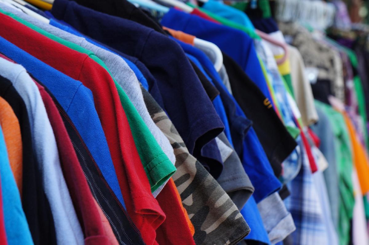 A rack of colorful shirts on hangers sorted for an estate sale